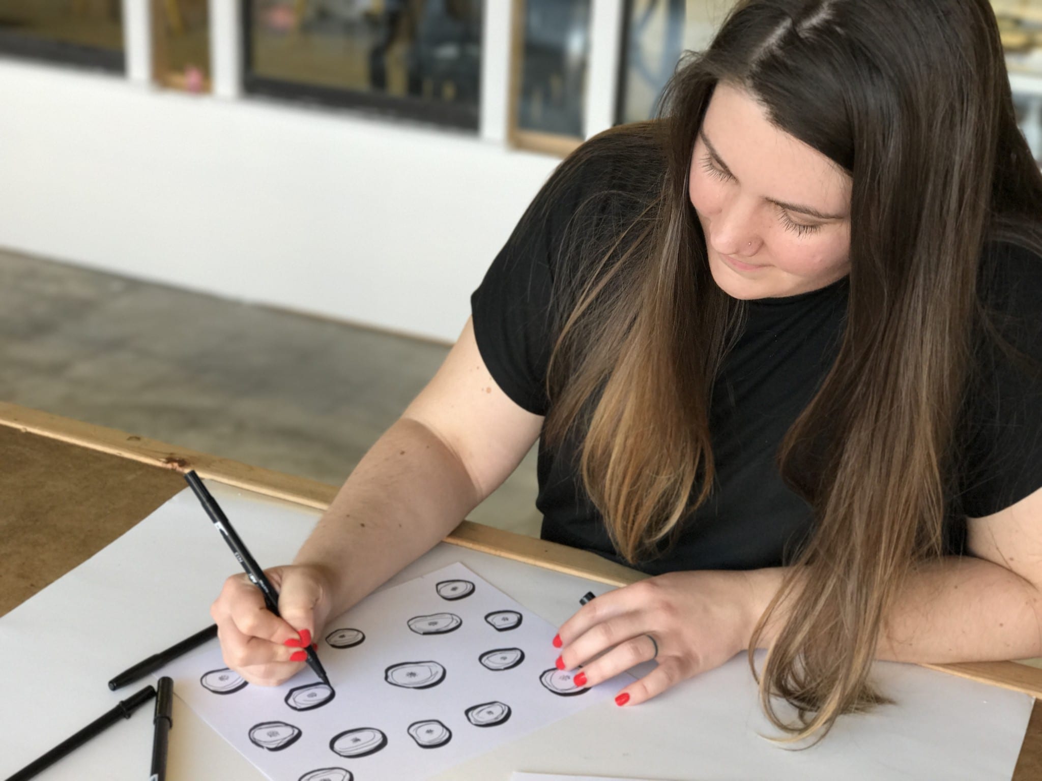 Woman drawing with a brush pen on paper.
