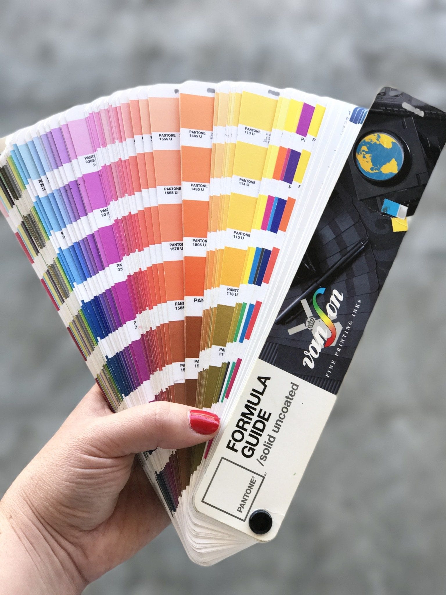 Paper Pantone Guide fanned out to show many color swatches.
