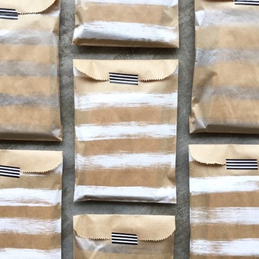 brown kraft paper bags painted with white and silver stripes and sealed with black & white washi tape